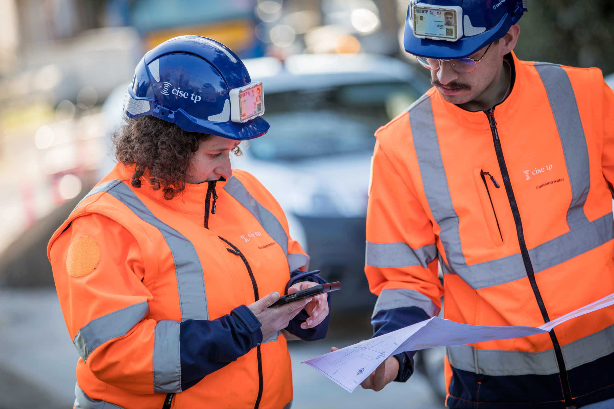 un homme et une femme étudies des plans sur un chantier